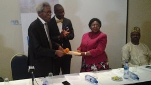 Chairman, Nigeria Prize for Science Advisory Board, Prof. Alfred Susu (left) hands over the entries to the  Chairman, Panel of judges, Dr. Catherine Falade as NLNG General Manager, External Relations Dr. Kudo Eresia-Eke (centre) applauds. Sitting (right) is one of the judges, Prof. Sunday Atawodi.