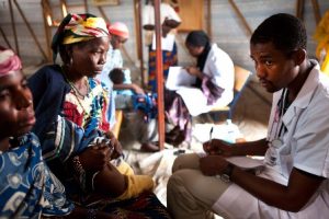 A doctor attends to a patient. A test is required to confirm malaria